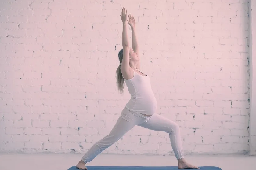 Femme enceinte réalisant une posture de guerrier en cours de yoga prénatal à Flayosc dans le Var.