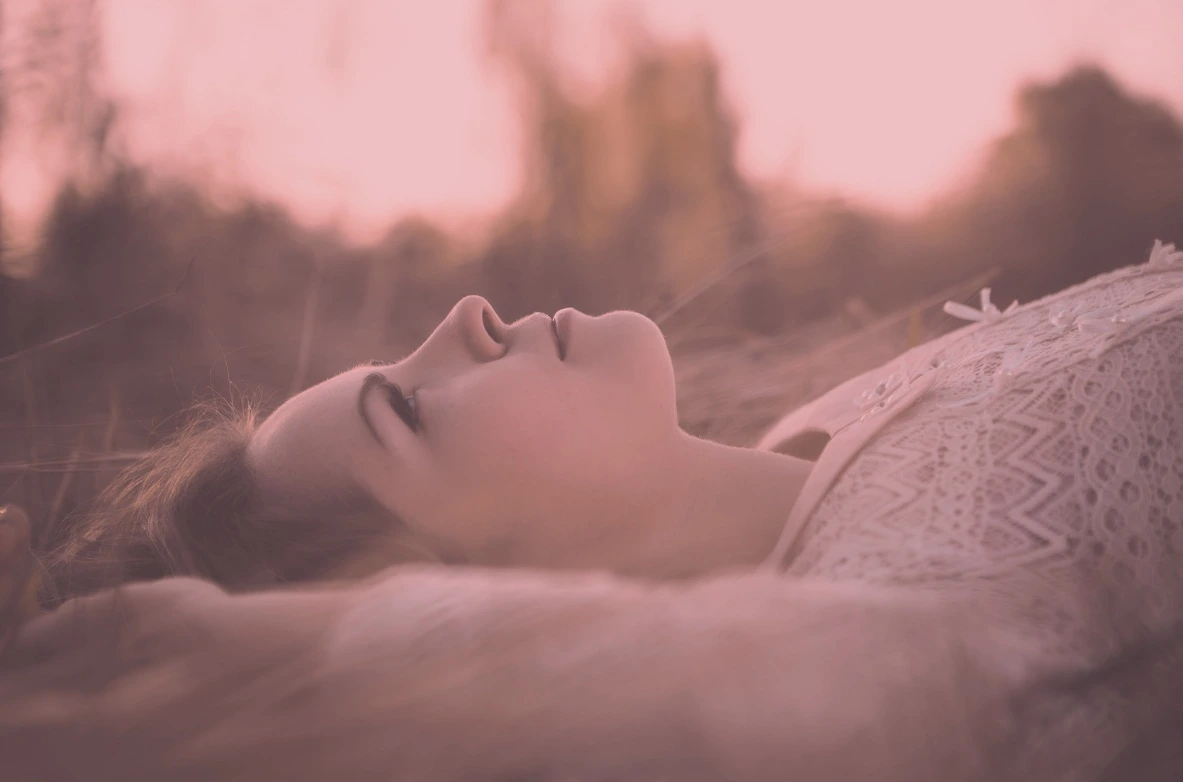 Femme allongée les yeux fermés en pleine détente, relaxation profonde en sophrologie pour femmes dans le Var