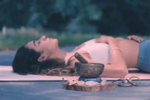 Femme relaxée recevant un soin énergétique avec un bol tibétain et des cristaux, séance de bien-être près de Lorgues, Var.