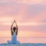 Femme méditant en posture de yoga au coucher du soleil lors d'une séance de yogathérapie et soin énergétique dans le Var.