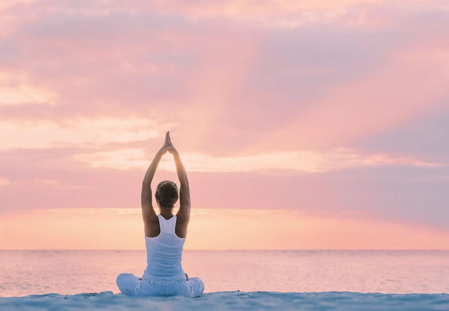 Femme méditant en posture de yoga au coucher du soleil lors d'une séance de yogathérapie et soin énergétique dans le Var.