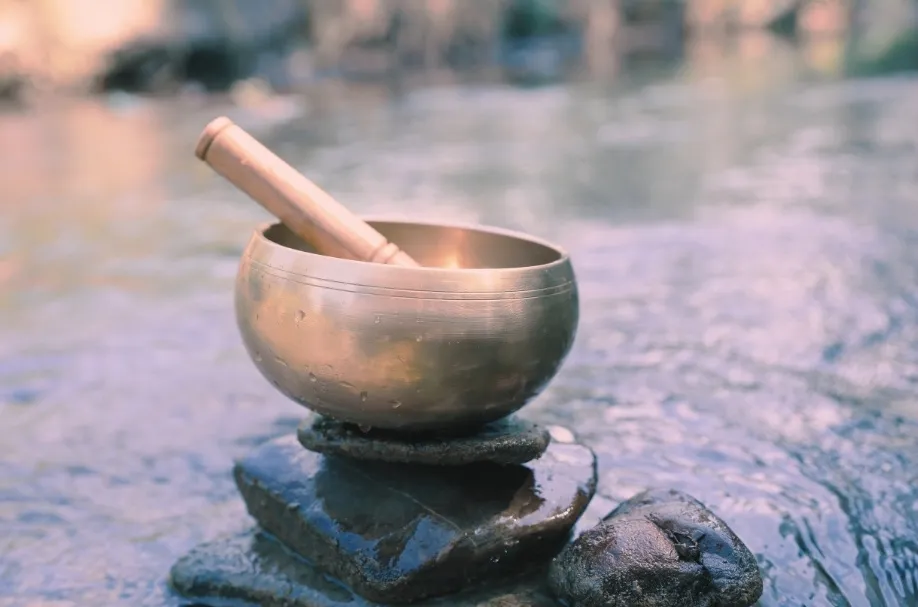 Bol chantant tibétain posé sur des galets au bord de l'eau lors d'une séance de soins énergétiques près de Lorgues dans le Var.