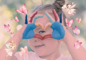 Petite fille souriante formant un cœur avec ses mains peintes lors d'un atelier ludique de sophrologie à Salernes, Var.